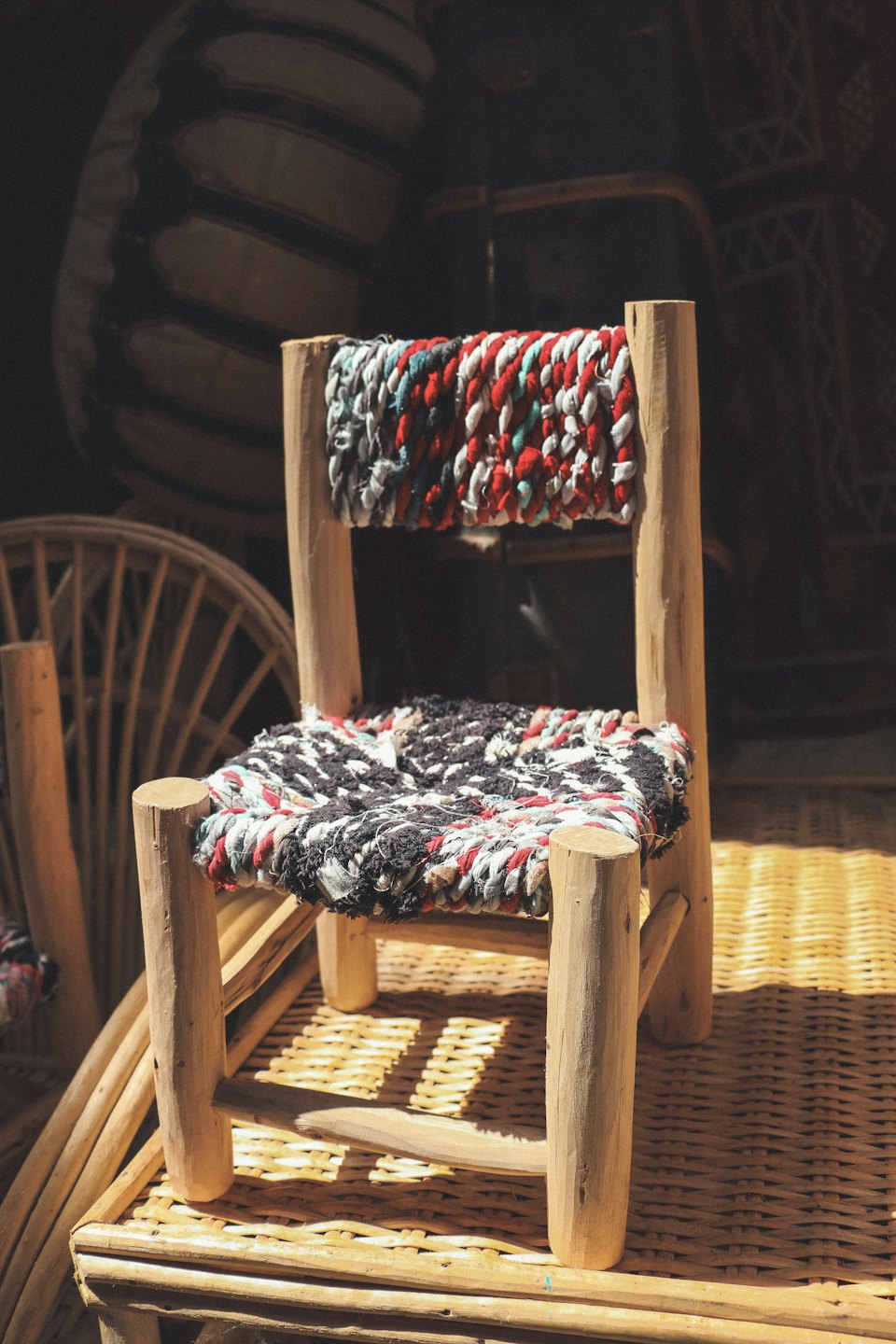 A handcrafted wooden chair with a woven fabric seat.