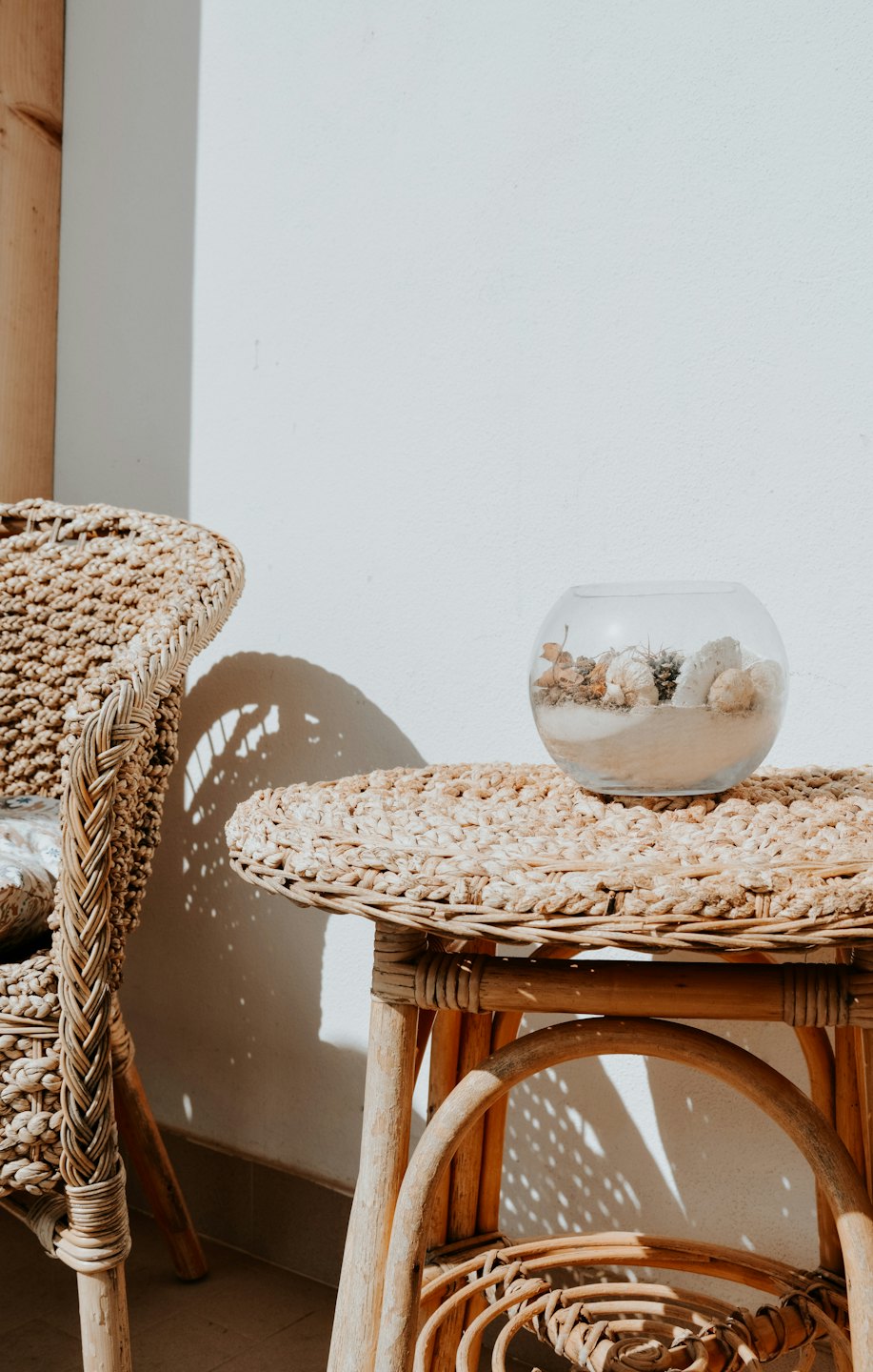 Natural woven rattan furniture sits against a bright wall.