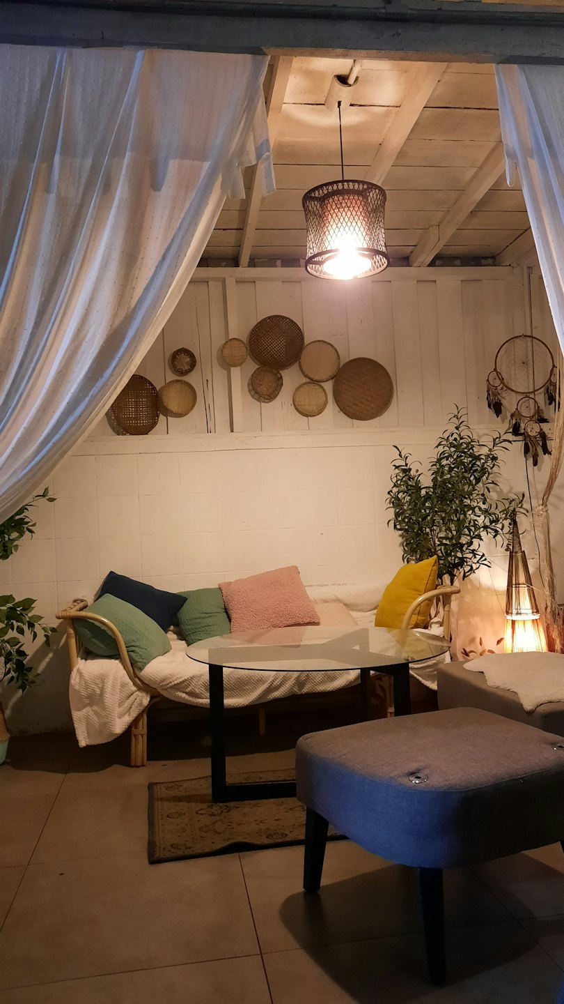 Rattan sofa with colorful cushions sits in a sunlit living room.